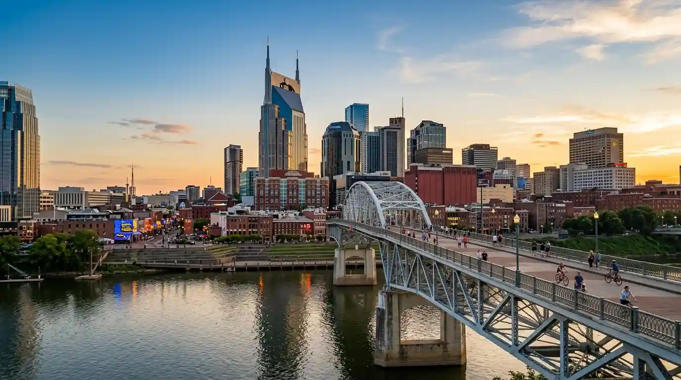 Nashville skyline and John Seigenthaler Pedestrian Bridge across the Cumberland River at sunset.